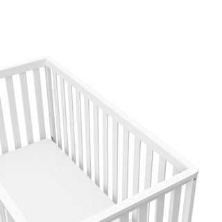 Close-up view of white with pebble gray crib's headboard 