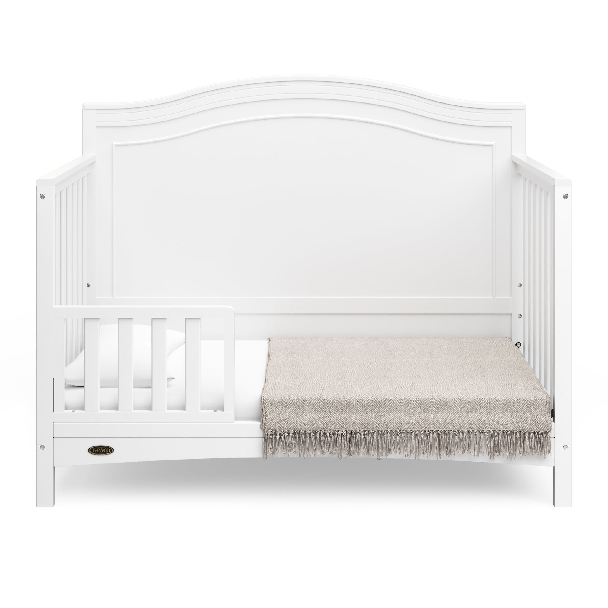 White crib in toddler bed conversion with one safety guardrail