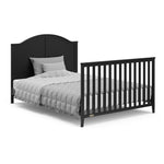 Black crib in full-size bed with headboard and footboard conversion