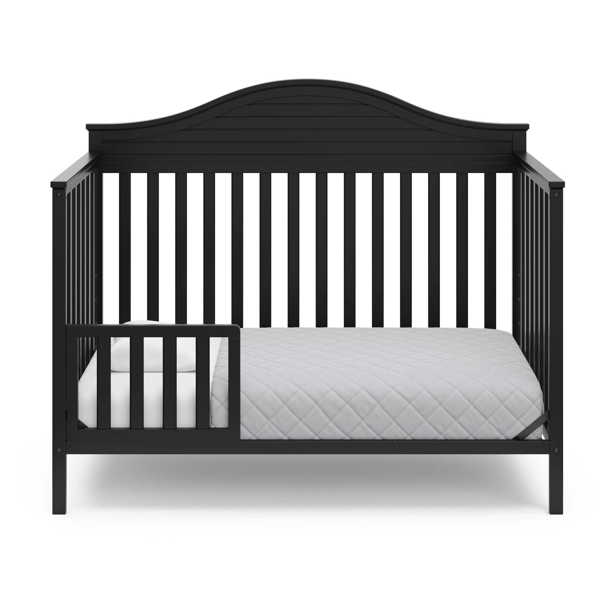 Black crib in toddler bed conversion with one safety guardrail