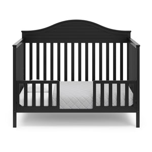 Black crib in toddler bed conversion with two safety guardrails