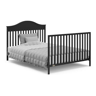 Black crib in full-size bed with headboard and footboard conversion