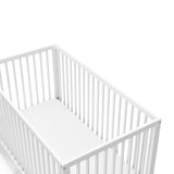 Close-up view of white crib with drawer