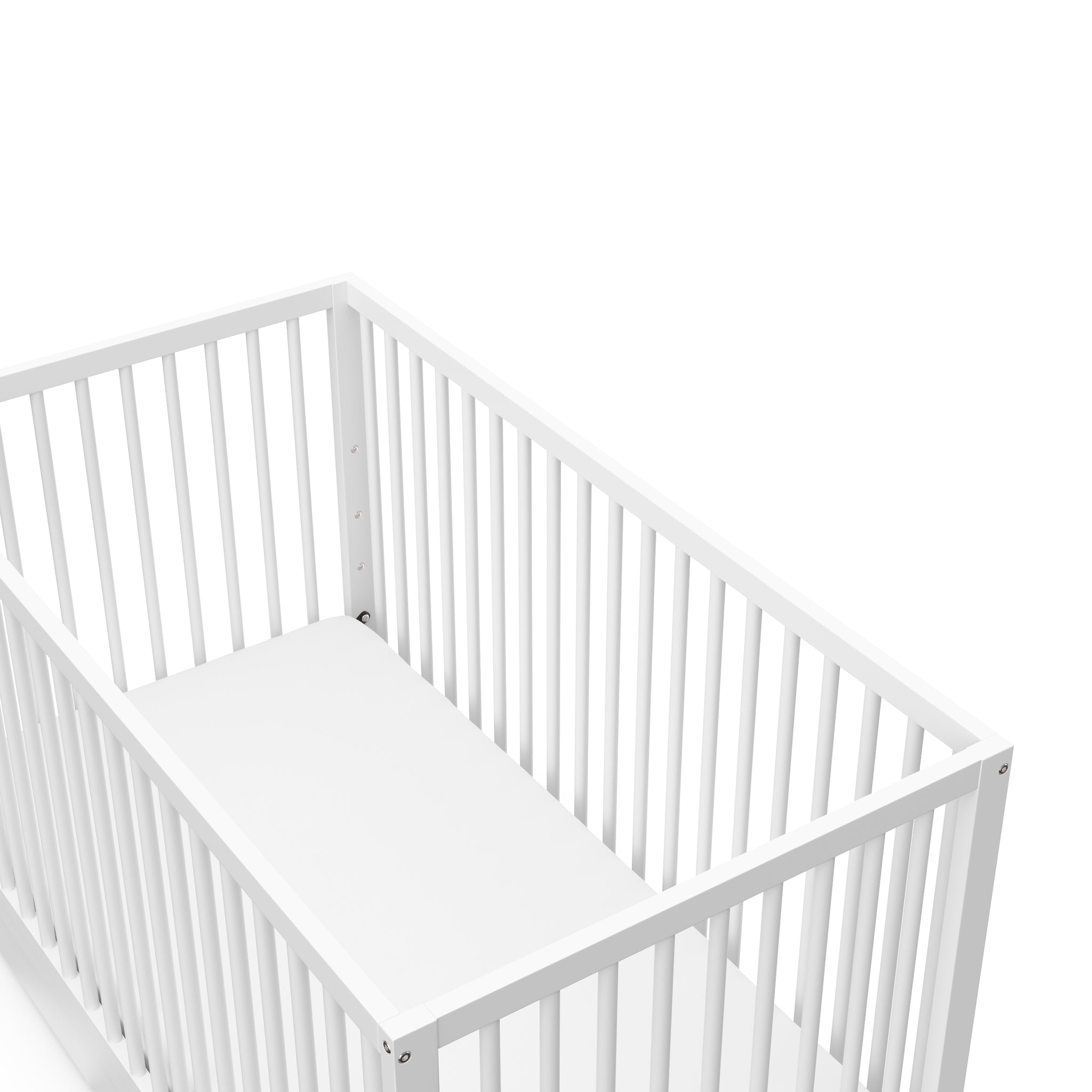 Close-up view of white crib with drawer