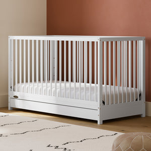 White crib with drawer in nursery