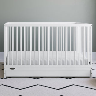 White crib with drawer in nursery