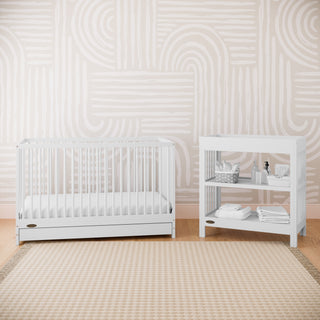 White crib with drawer in nursery