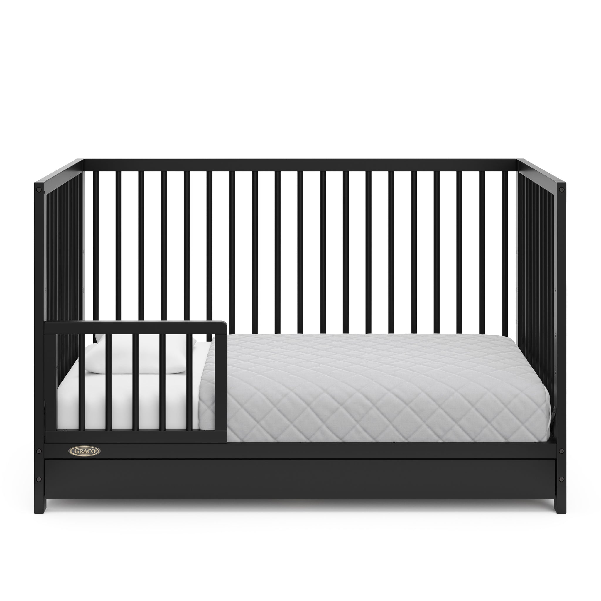 Black crib with drawer in toddler bed conversion with one safety guardrail