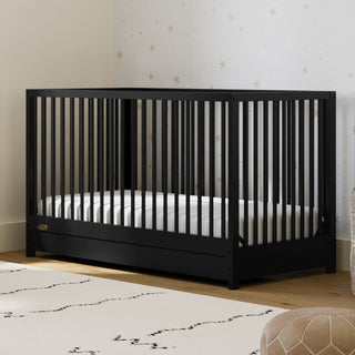 Black crib with drawer in nursery