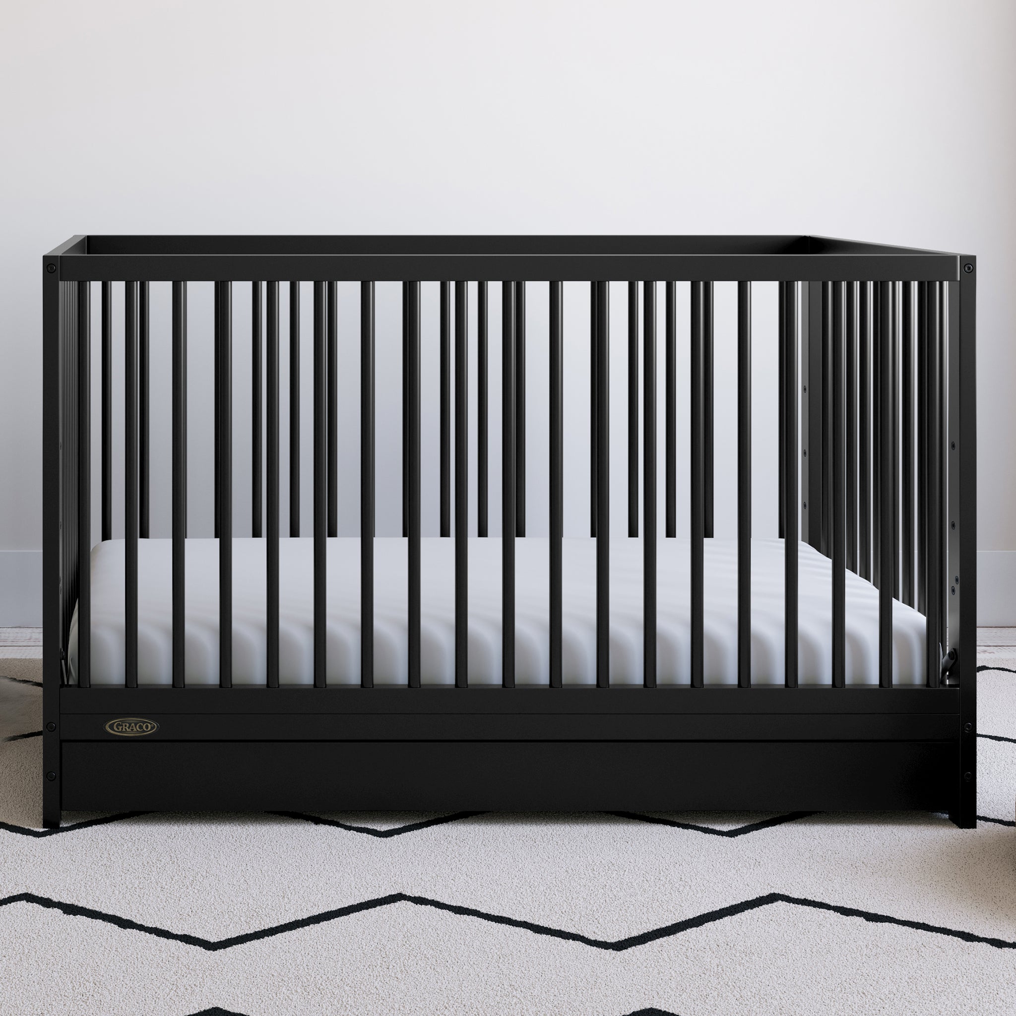 Black crib with drawer in nursery