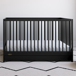 Black crib with drawer in nursery