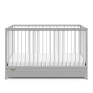 Front view of Pebble gray crib with open drawer