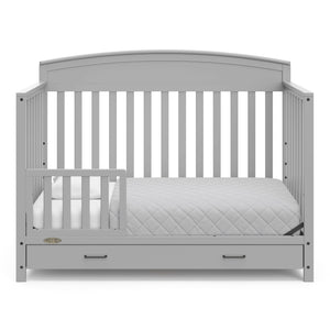 Pebble gray crib with drawer in toddler bed conversion with one safety guardrail