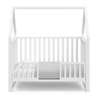 White crib in toddler bed conversion with two safety guardrails 