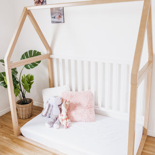 White crib with driftwood in toddler bed conversion  in nursery