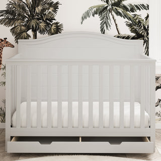 White crib with drawer in nursery with open drawer