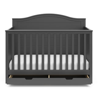 Front view of gray crib with open drawer