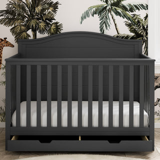 gray crib with open drawer in nursery