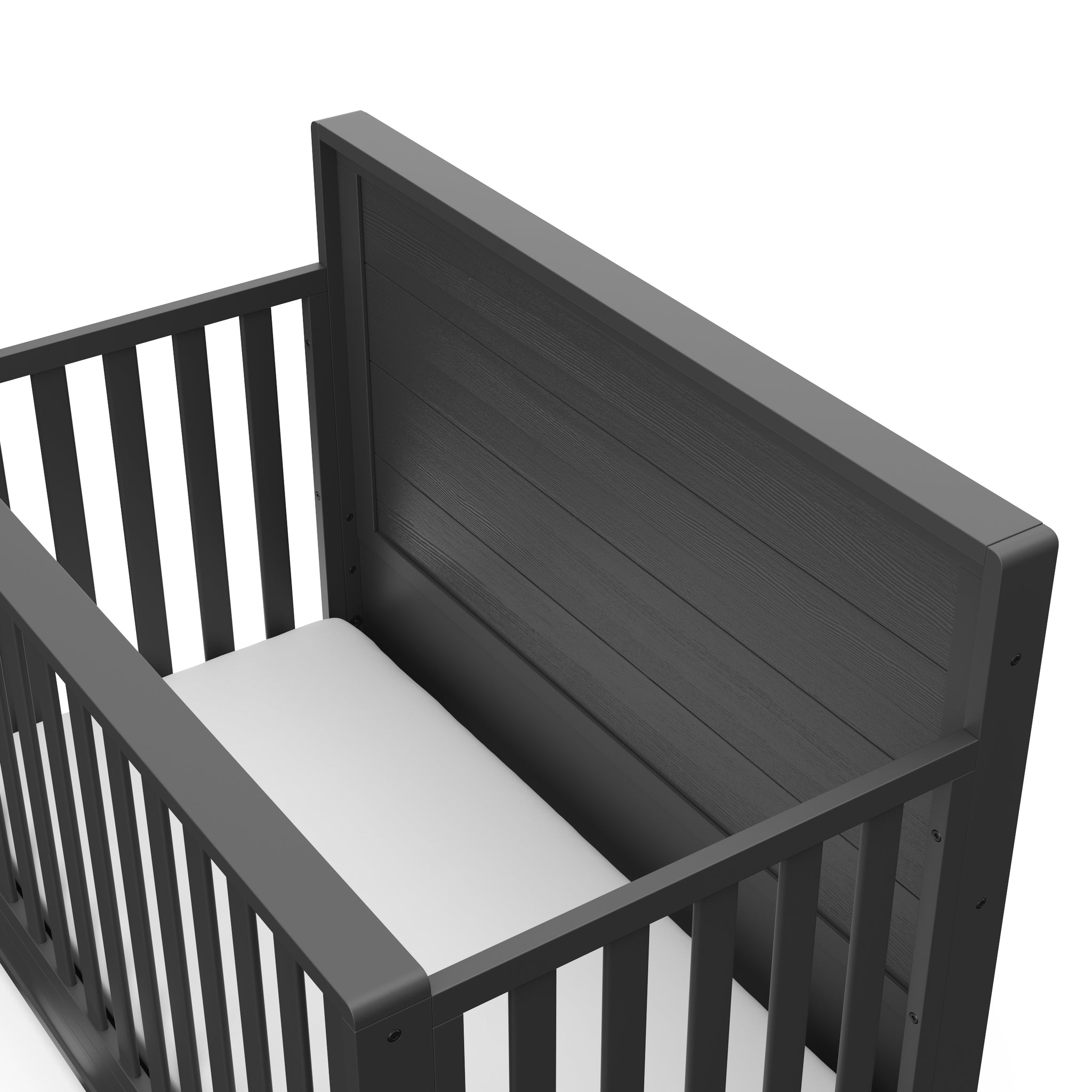 Close-up view of gray crib with drawer headboard