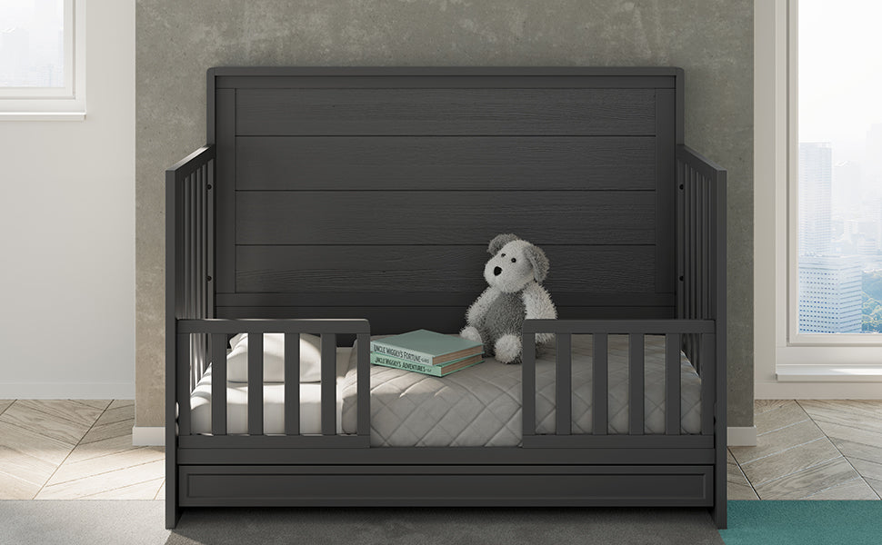 gray crib with drawer in toddler bed conversion with two safety guardrails in nursery