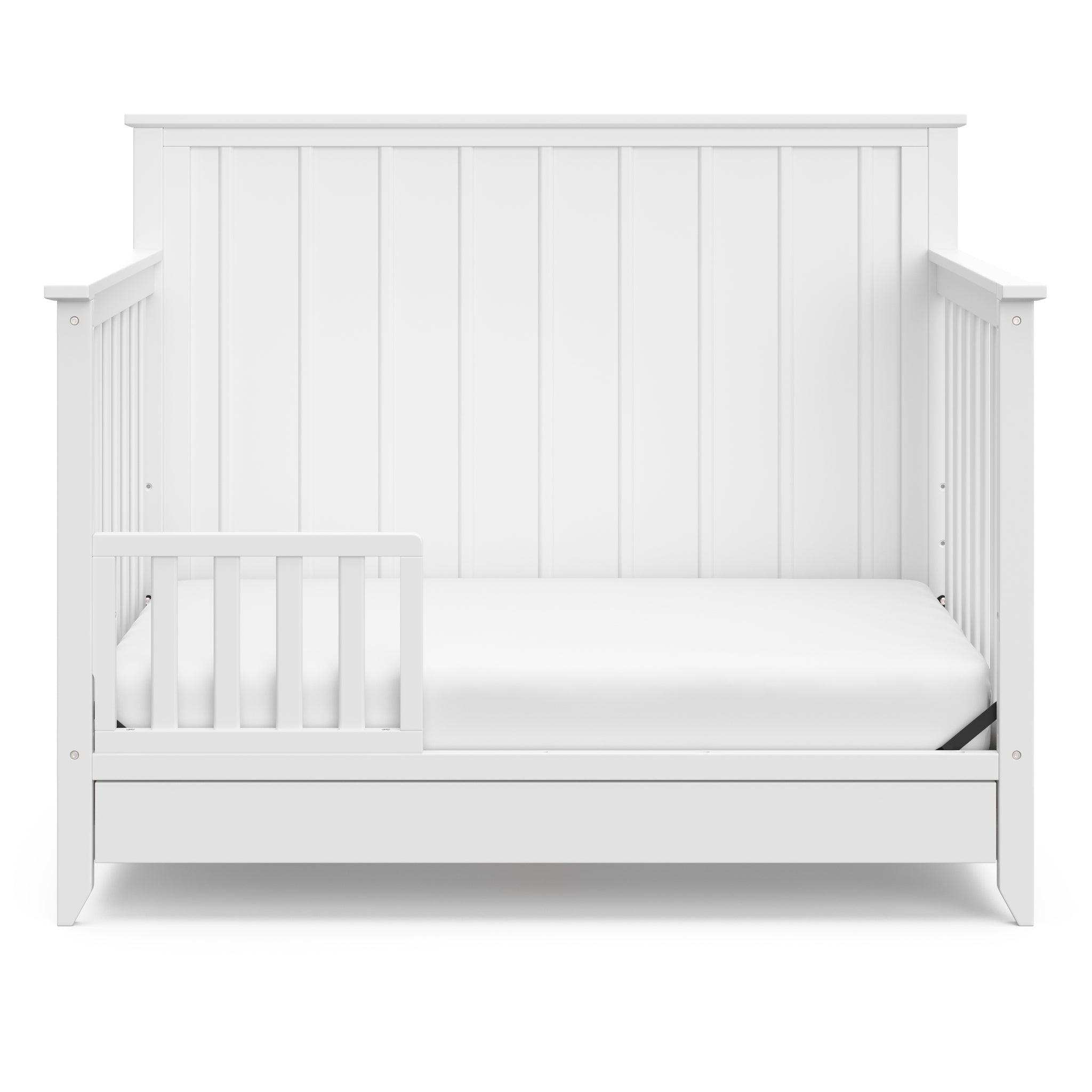 White crib in toddler bed conversion with one safety guardrail