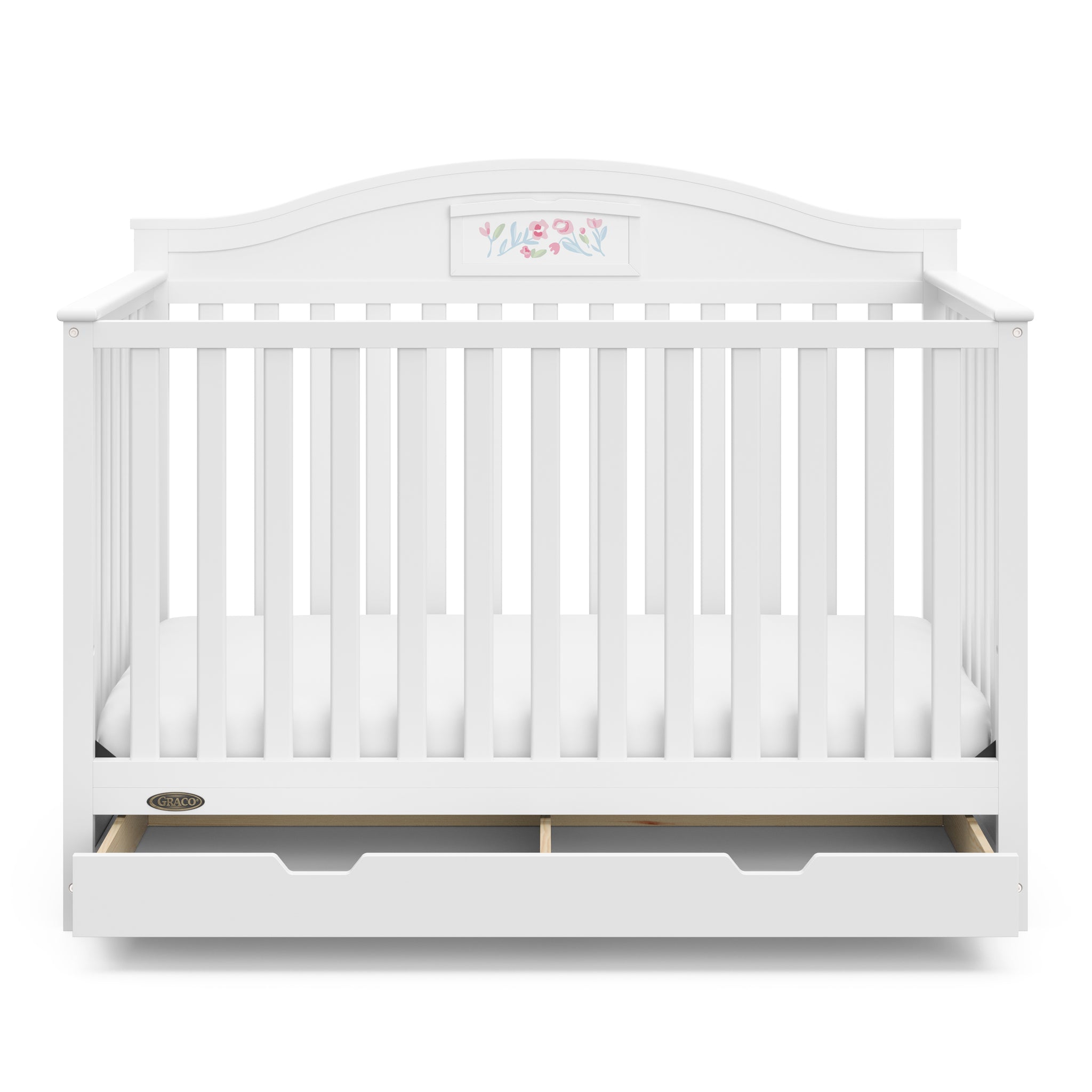 Front view of white crib with open drawer