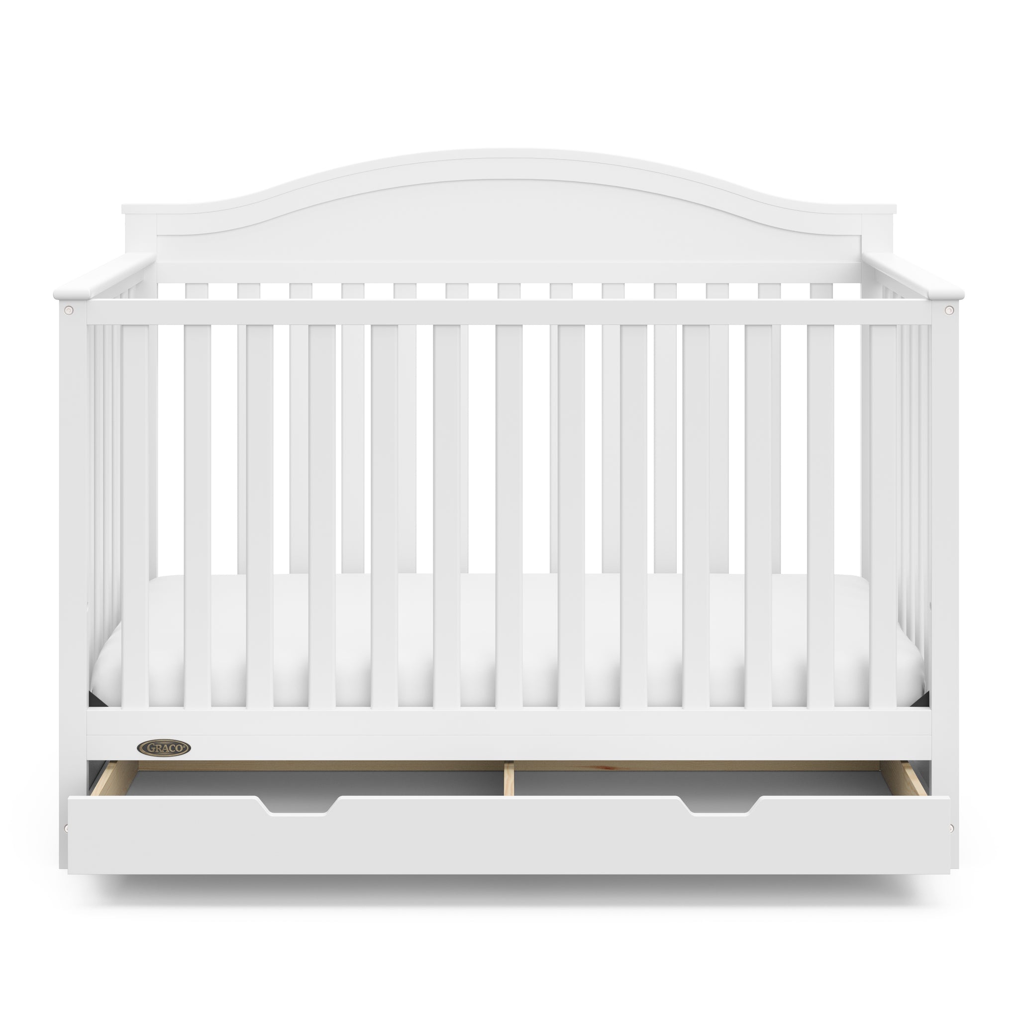 Front view of white crib with open drawer