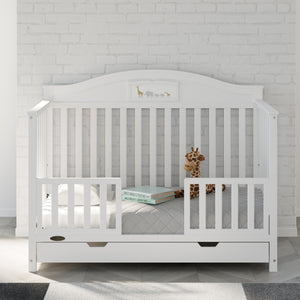 white toddler safety guardrail with slats applied in toddler bed, in nursery