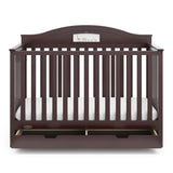 Front view of espresso crib with open drawer