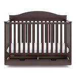 Front view of espresso crib with open drawer