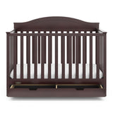Front view of espresso crib with open drawer