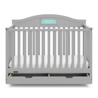 Front view of Pebble gray crib with open drawer