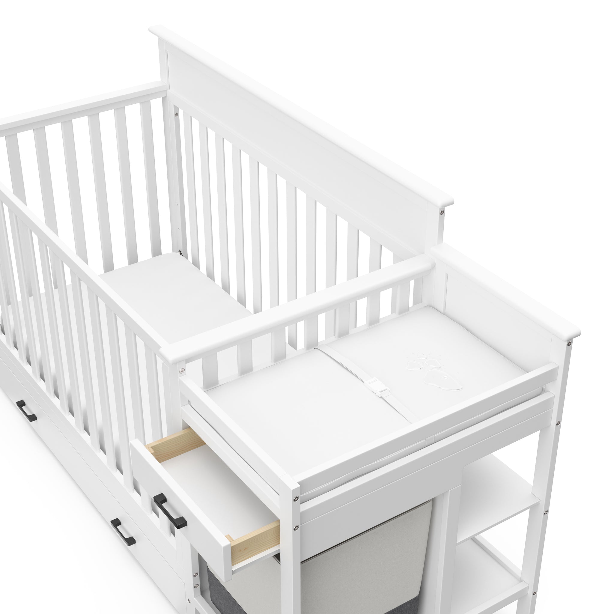 Close-up view of White crib and changer with open drawer