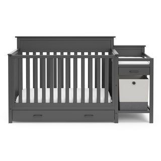 Front view of gray crib and changer with drawer
