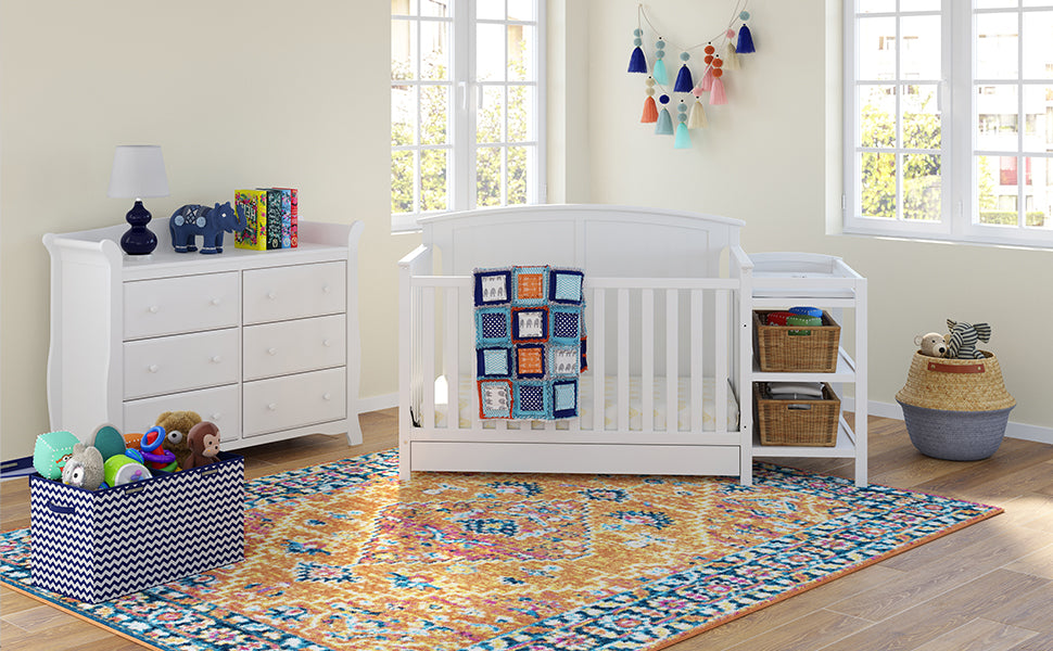 White crib and changer in nursery with 6 drawer dresser