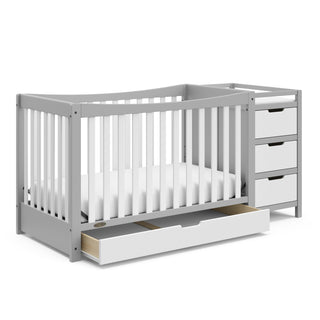 Pebble gray and white crib and changer angled with open drawer