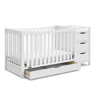 White crib and changer angled with open drawer