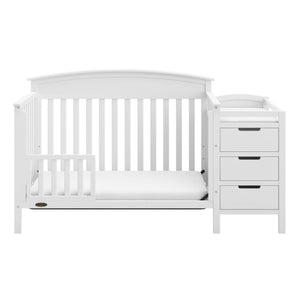 White crib in toddler bed conversion with one safety guardrail