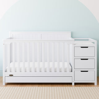 White crib and changer with drawer in nursery