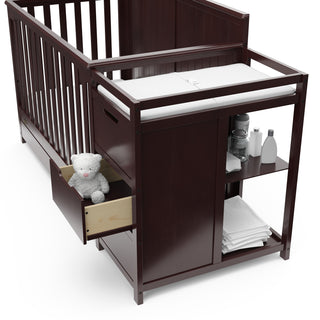 Close-up view of espresso crib and changer with open drawer