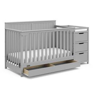 Pebble gray crib and changer angled with open drawer