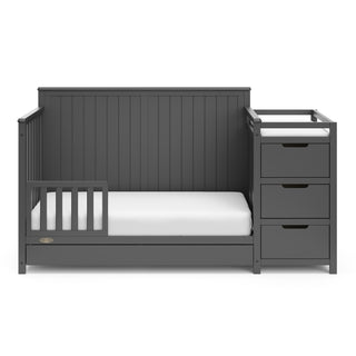 gray crib and changer with drawer in toddler bed conversion with one safety guardrail 