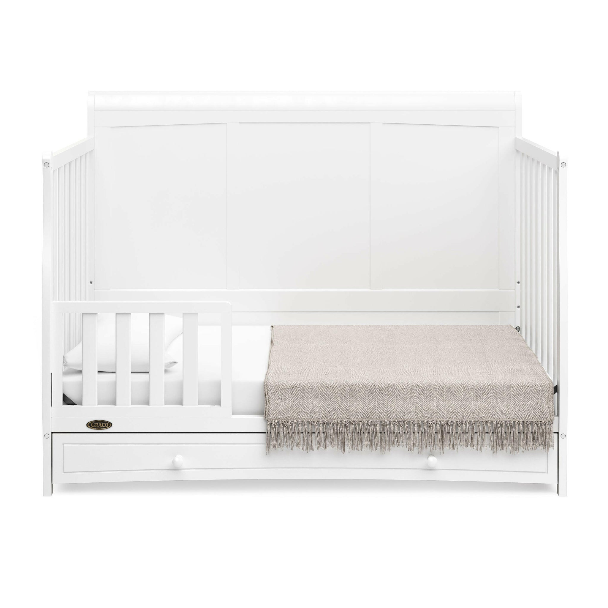 White crib with drawer in toddler bed conversion with one safety guardrail