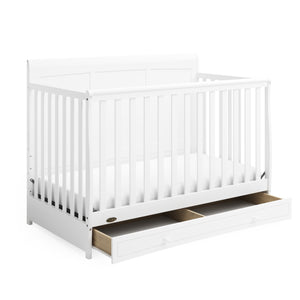 White crib with open drawer angled