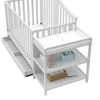 Close-up view of White crib and changer with open drawer