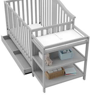 Close-up view of Pebble gray crib and changer with open drawer