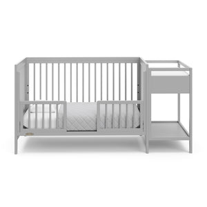 Pebble gray crib in toddler bed conversion with two safety guardrails