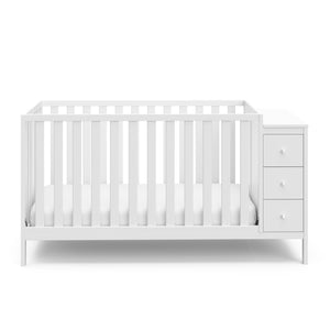 Front view of white crib with storage