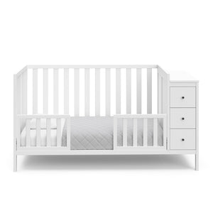 White crib with storage in toddler bed conversion with two safety guardrails
