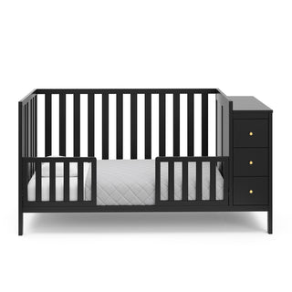 black crib with storage in toddler bed conversion with two safety guardrails